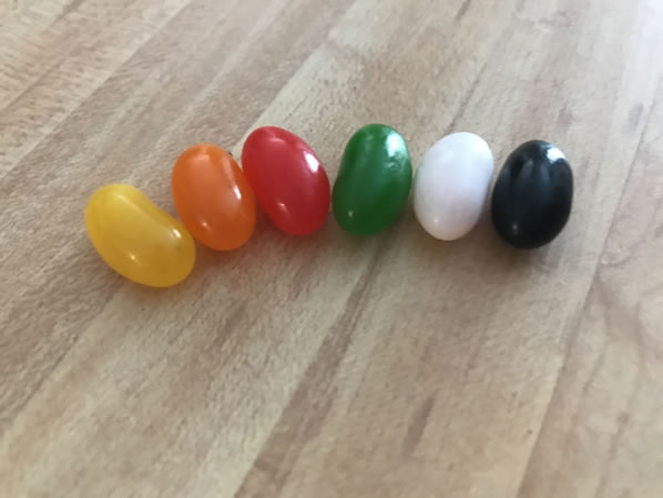 One of each flavor of Ass Kickin' jelly beans lined up on a table